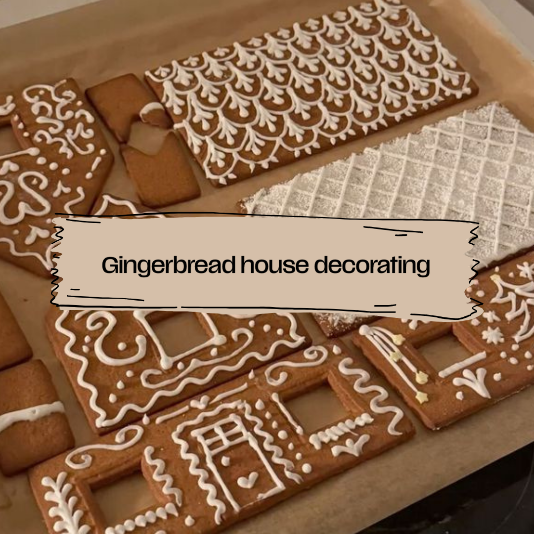 Decorated gingerbread house pieces arranged on a baking sheet, including rectangular house panels with white icing patterns and small gingerbread figures. A beige label overlay reads 'Gingerbread house decorating'.