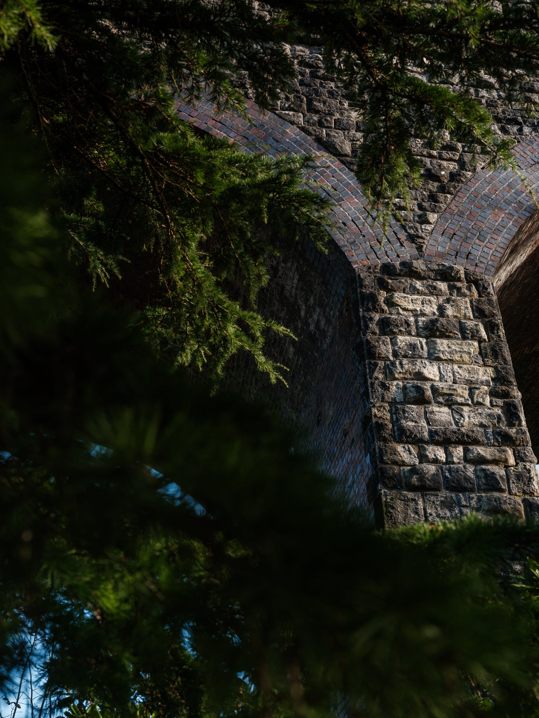 Stone archway of the Kilver Court Viaduct surrounded by greenery
